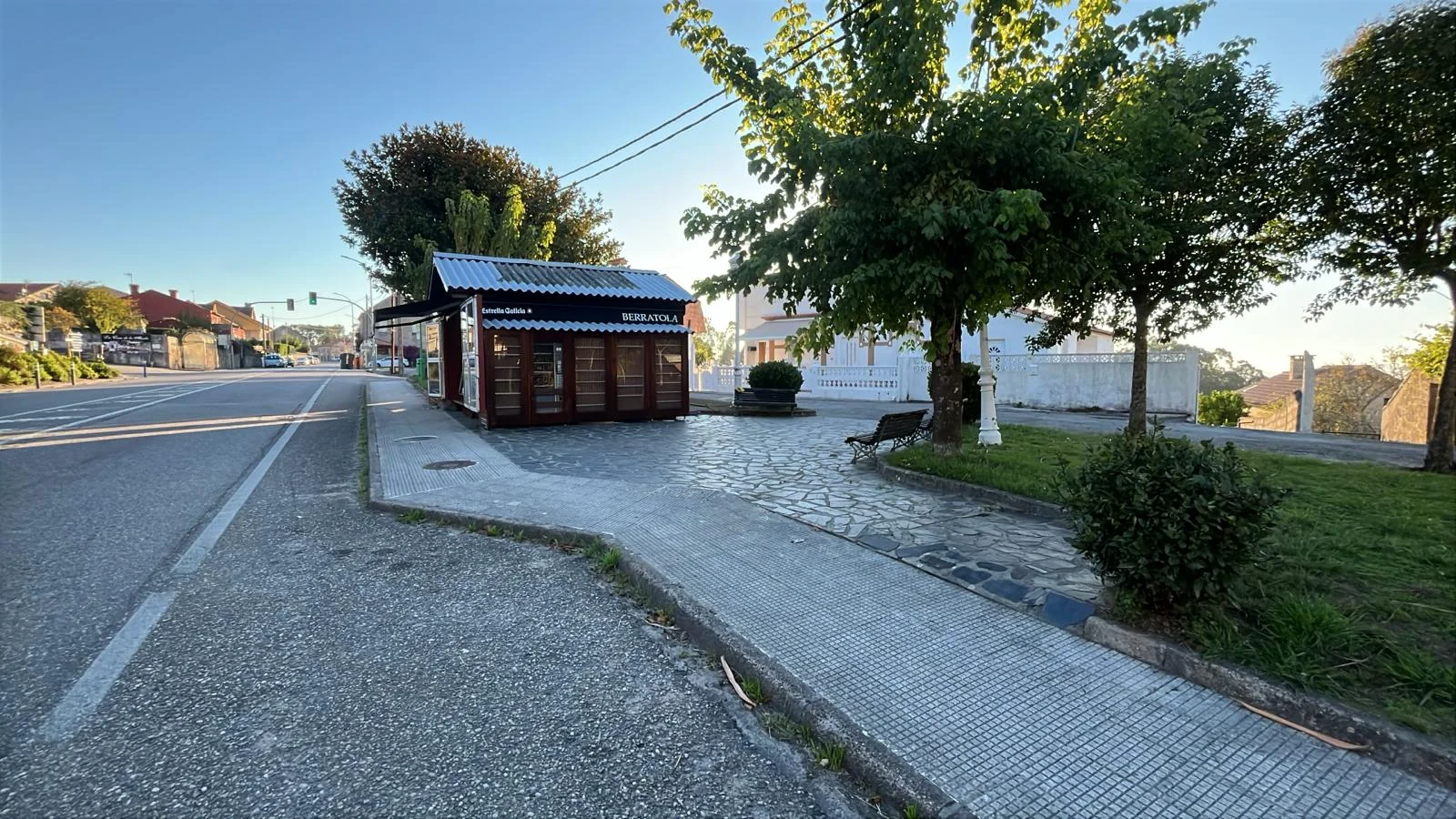 El kiosko Berratola junto a la acera, los bancos y los árboles de Priegue