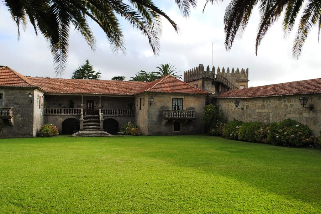 Pazo de Urzáiz visto desde su jardín, con balaustrada de piedra, escalinata y torre almenada