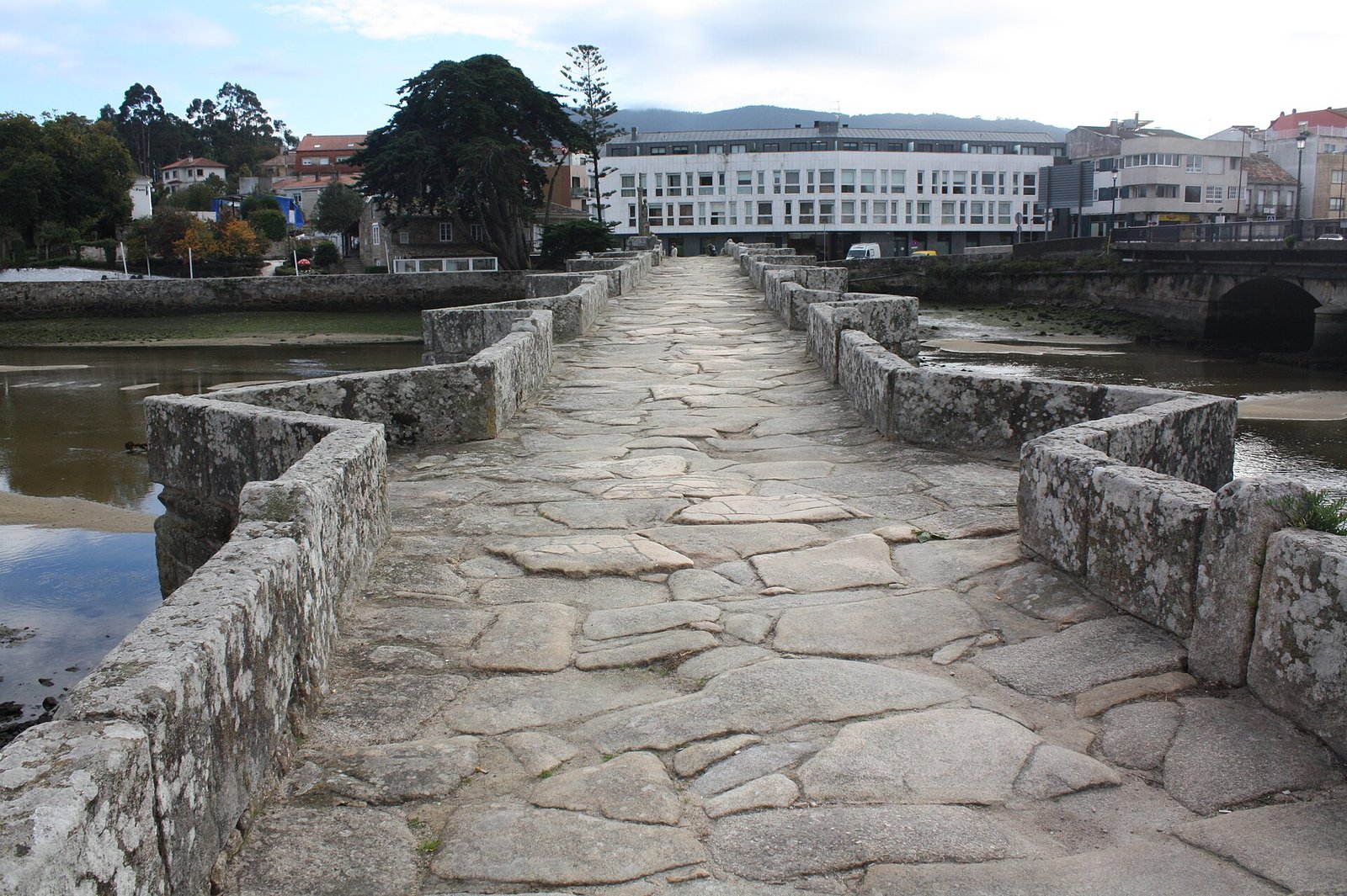 Calzada de losas del puente medieval de A Ramallosa, con la marisma a los lados