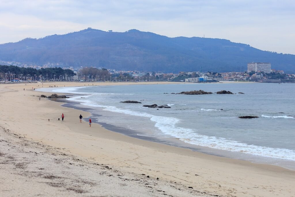 Playa de Samil en Vigo, con el arenal en curva y el monte al fondo